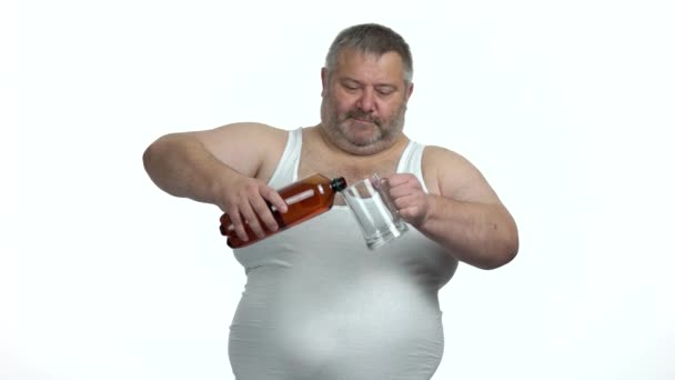 Fat man vierte cerveza de la botella en un vaso de cerveza . — Vídeo de stock