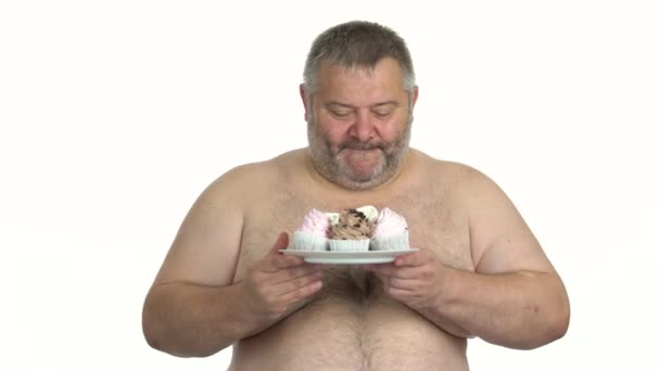 Fett hemdlosen Mann hält Teller mit Kuchen. — Stockvideo