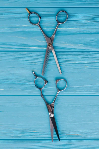 Hairdressing scissors on color background.