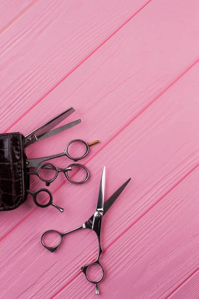 Tijeras de peluquería sobre mesa de madera rosa . — Foto de Stock