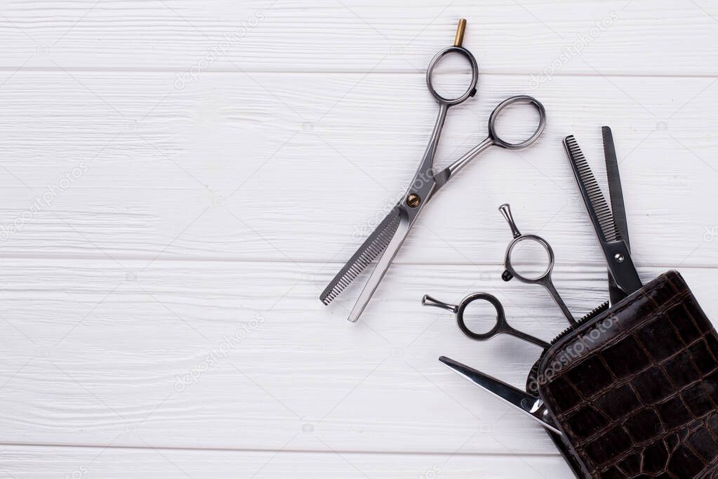 Professional hairdresser scissors on wooden background.