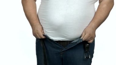 Obez yetişkin adam dar kot pantolon giymeye çalışıyor..
