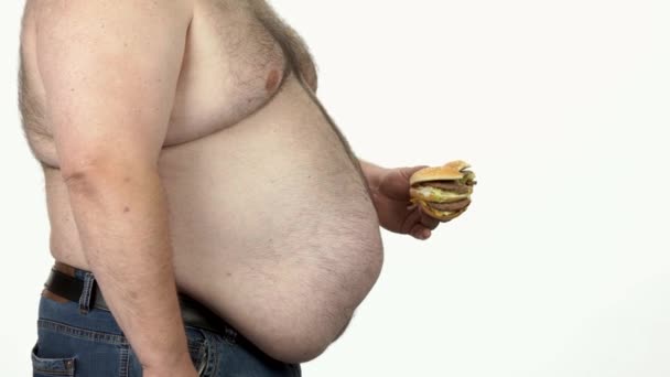 Hombre gordo comiendo hamburguesa de comida rápida . — Vídeos de Stock