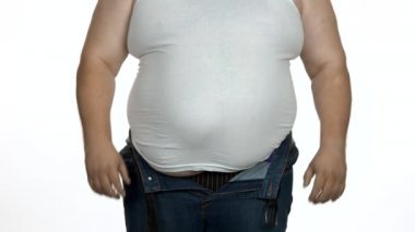 Şişman adam koca karnına dokunuyor..