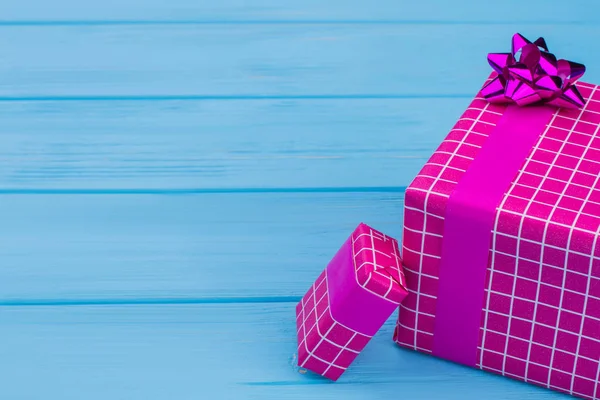 Фіолетові картаті подарункові коробки на синьому фоні . — стокове фото