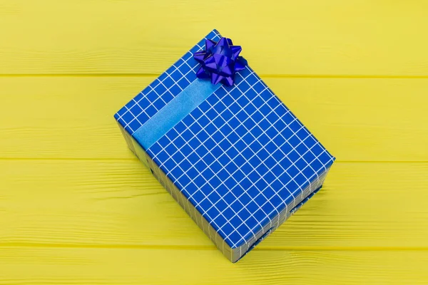 Dark blue gift box on yellow background.