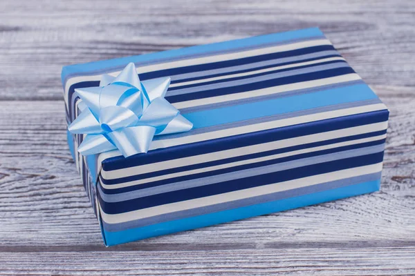Kék csíkos ajándék doboz fa háttér. — Stock Fotó
