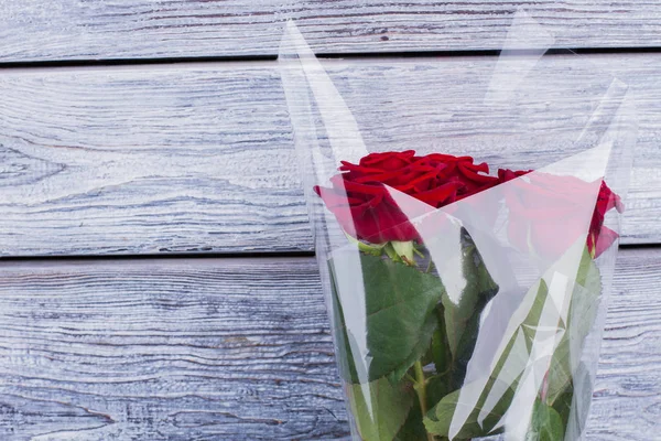 Röda rosor förpackade i transparent förpackning. — Stockfoto