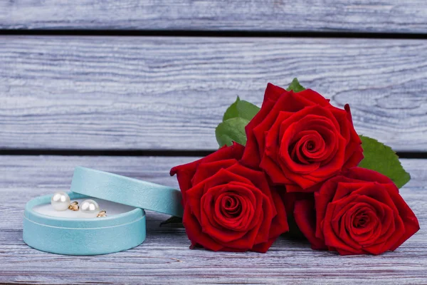 Красные розы и коробка с жемчужными серьгами . — стоковое фото