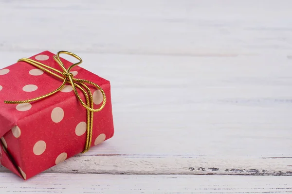Caixa de presente de bolinhas vermelhas com arco dourado . — Fotografia de Stock