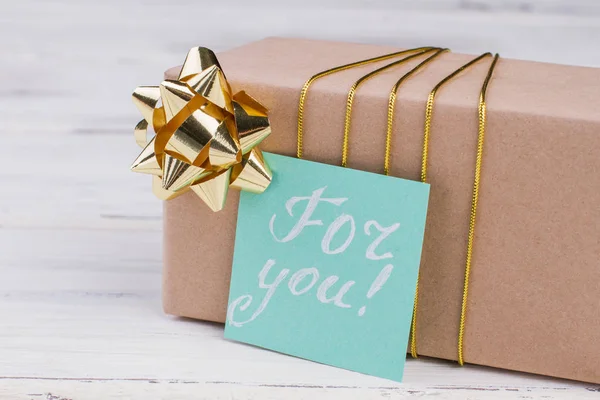 Caja de regalo con arco y tarjeta de felicitación . —  Fotos de Stock
