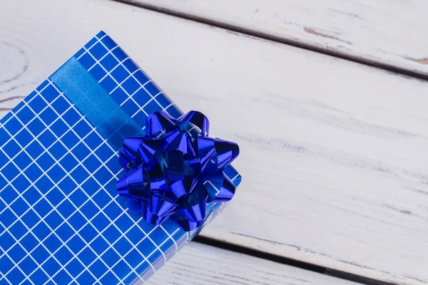 Blauwe geschenkdoos op witte houten ondergrond. — Stockfoto