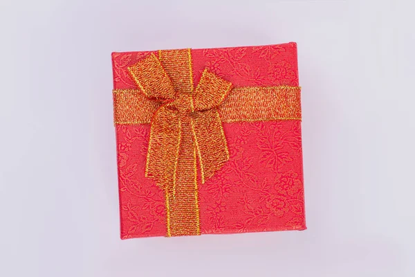 Boîte cadeau rouge avec motif floral doré et arc . — Photo