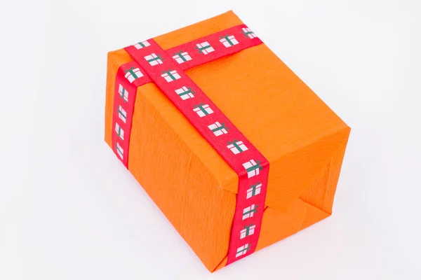 Πορτοκαλί συσκευασία δώρου με κόκκινη κορδέλα. — Φωτογραφία Αρχείου