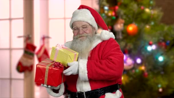 Święty Mikołaj trzyma prezenty z kciukiem w górze. — Wideo stockowe
