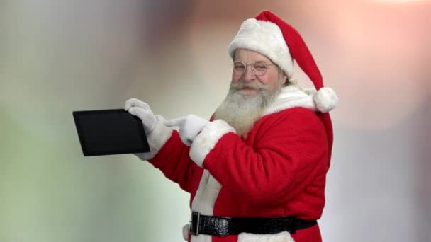 Babbo Natale in occhiali mostrando tablet pc . — Video Stock