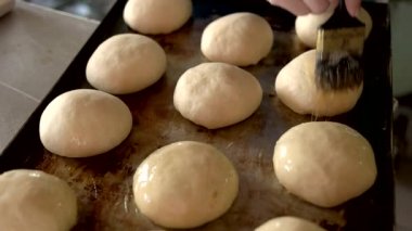 Çiğ çörekleri yumurta sarısında fırçalamak.