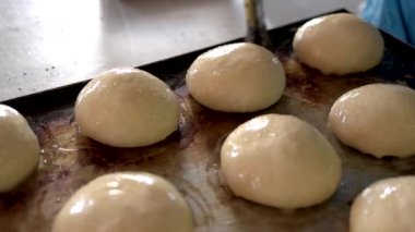 Fırıncı elleri yumurtanın sarısını çöreğe sürer..