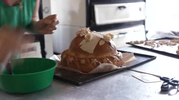 Bäckerin dekoriert Rundbrot. — Stockvideo