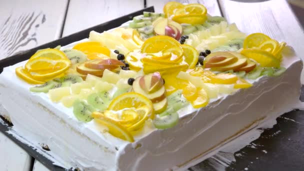 Белый торт украшен различными фруктами . — стоковое видео