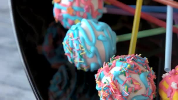 Cakes with colorful frosting on sticks. — Stock Video