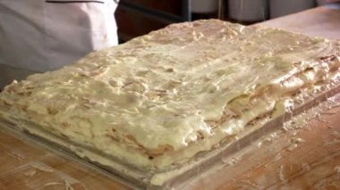 Pasta şefi bisküvi kırıntılarıyla pasta süslüyor..