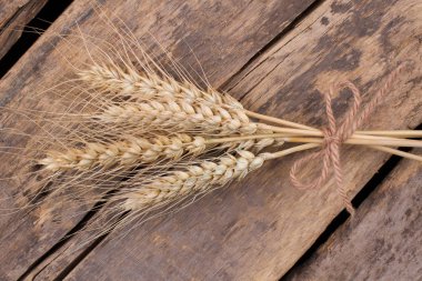 Eski ahşap arka planda altın buğday kulakları.