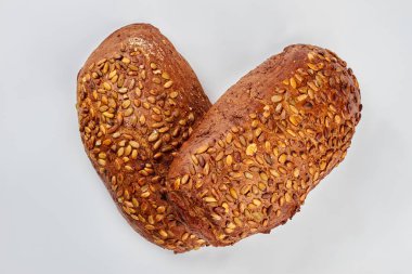 Beyaz arka planda kabak tohumlu kahverengi ekmek.