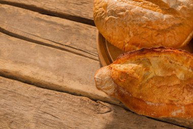Ahşap zemin üzerinde altın kabuklu doğal ekmek..