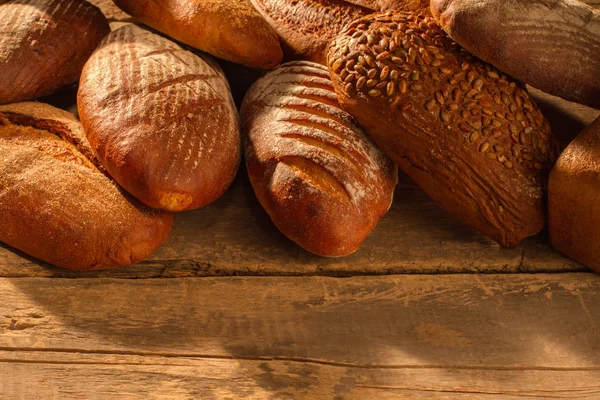 Haufen natürlicher Brotlaibe auf Holzboden. — Stockfoto