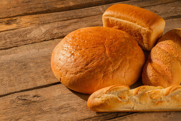 Bread and bakery products on wooden background.
