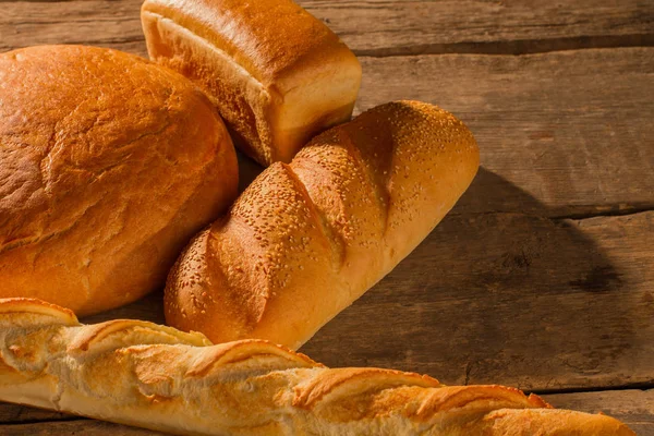 Pão francês e pão tradicional sobre fundo de madeira . — Fotografia de Stock