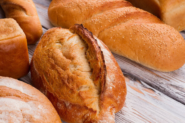 Fresh bread with crust on wooden background.