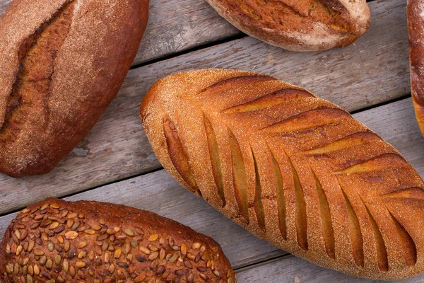 Crusty bread loaves on wooden background.