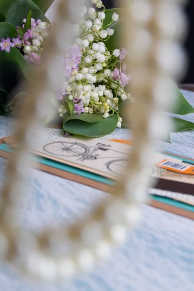 Collar de perlas desenfocadas y ramo de flores sobre fondo . — Foto de Stock