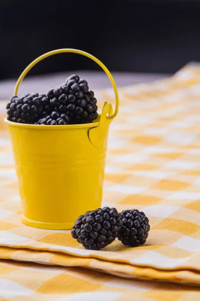 Small yellow bucket full of blackberries. — Stock Photo, Image