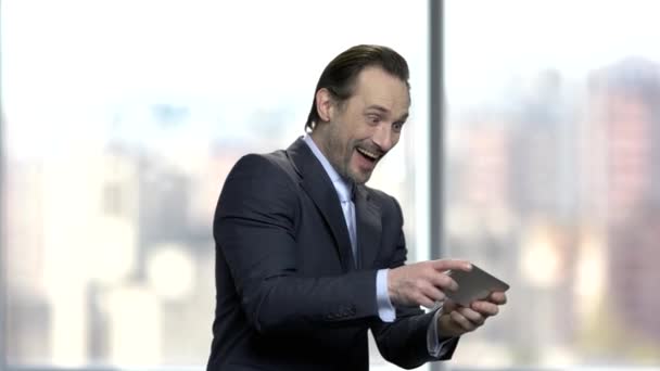 Opgewonden Kaukasische zakenman spelen spel op smartphone. — Stockvideo