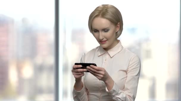 Office nő játszik játék az ő smartphone. — Stock videók