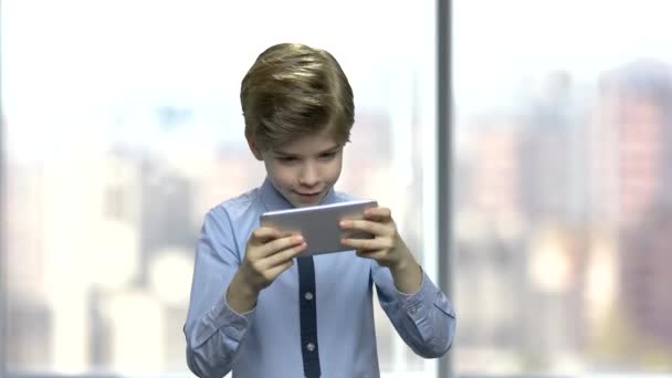 Handsome boy playing video game on smartphone. — ストック動画