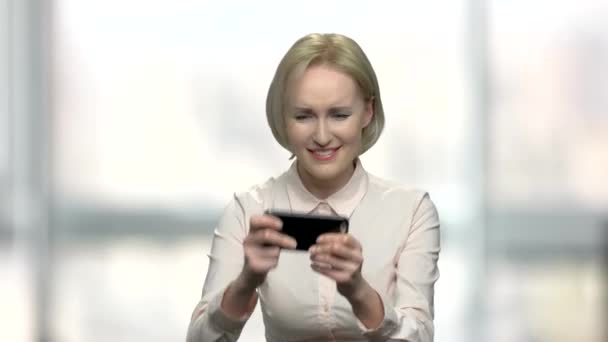 Office woman playing game on her smartphone. — Stock Video
