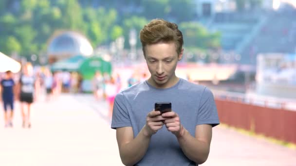 Teen boy texting message on his phone. — Stock Video