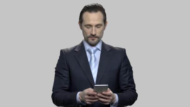 Уверенный бизнесмен печатает сообщение на своем смартфоне . — стоковое видео