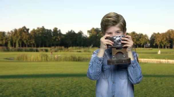 Niño pequeño usando la cámara de fotos al aire libre . — Vídeos de Stock