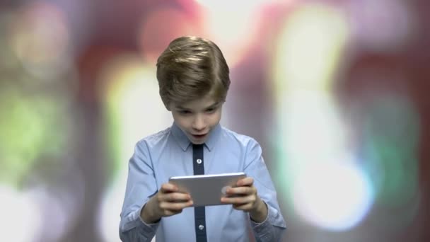 小さな男の子はスマートフォンでオンラインゲームをプレイ. — ストック動画