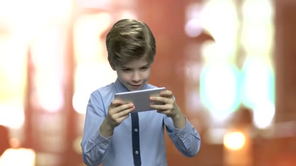 Emocionado niño jugando juego en su teléfono . — Vídeos de Stock