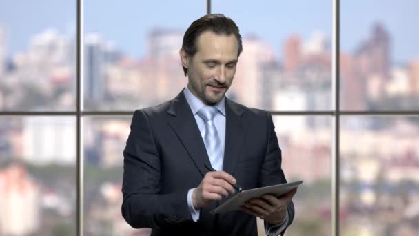 Succesvolle volwassen zakenman werkt op tablet apparaat. — Stockvideo