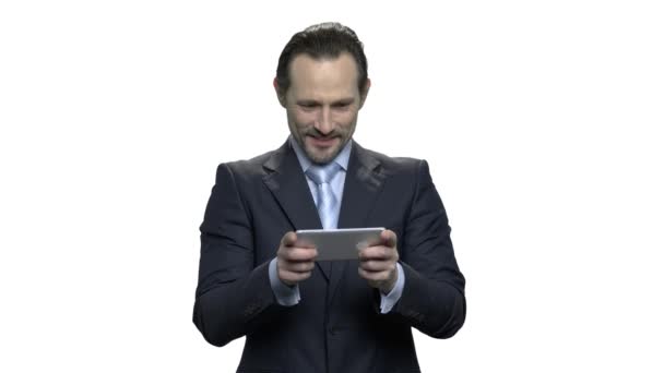 Homem de negócios maduro concentrado joga jogo no smartphone . — Vídeo de Stock