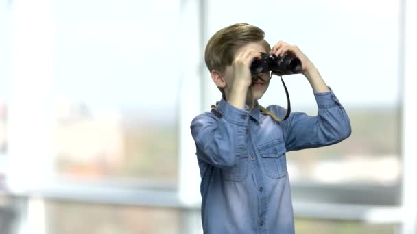 Leende kaukasiska pojke tittar genom kikare. — Stockvideo