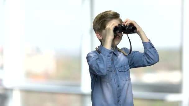 Lächelnder kaukasischer Junge, der durch ein Fernglas schaut. — Stockvideo