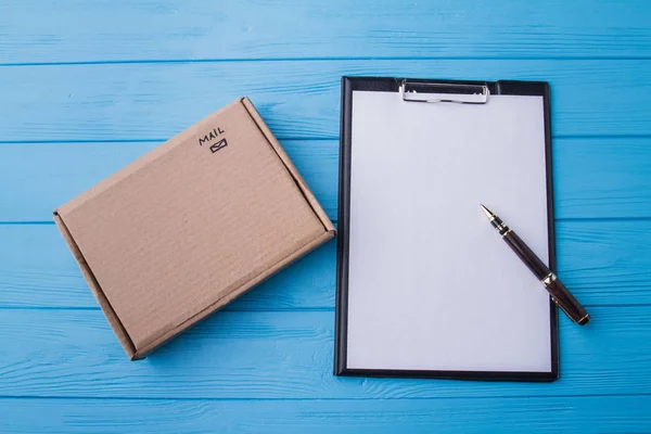 Clipboard e caixa de papelão, flat lay . — Fotografia de Stock